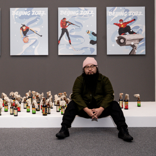 dissident Artist Badiucao stands in front of his Beijing 2022 Winter Olympics exhibition