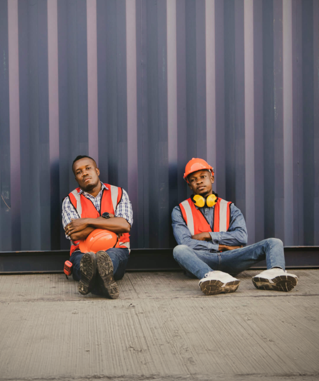 Two migrant workers pose for a picture in their construction gear for the Human Rights Foundations report titled "Authoritarianism and Trafficking in Persons".