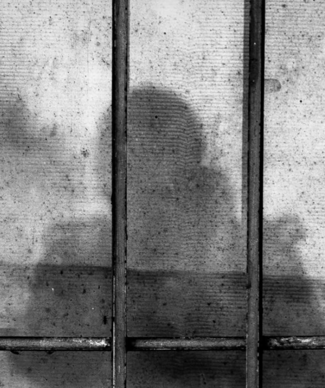 Shadow of a prisoner behind bars