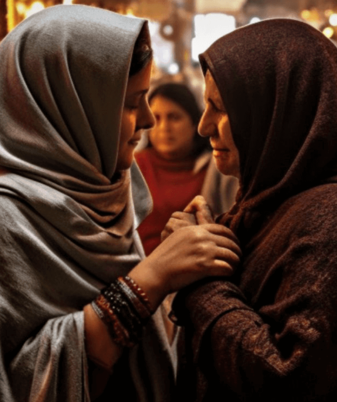 Powerful image depicting two Iranian women consoling each other