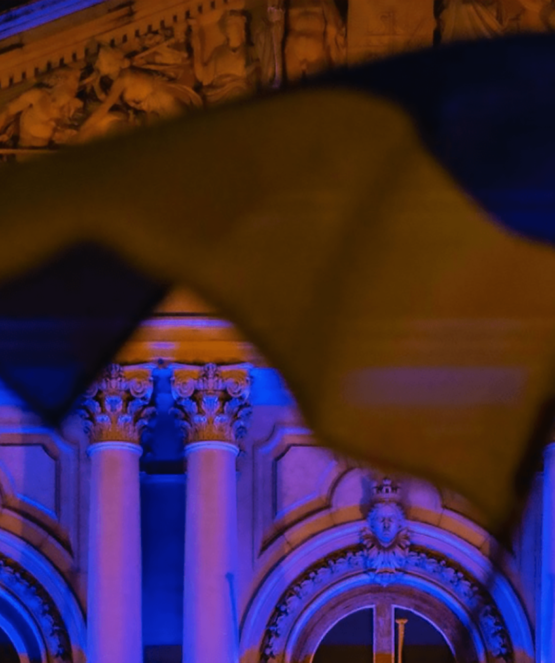 Ukrainian flag flying in front of a parliamentary building