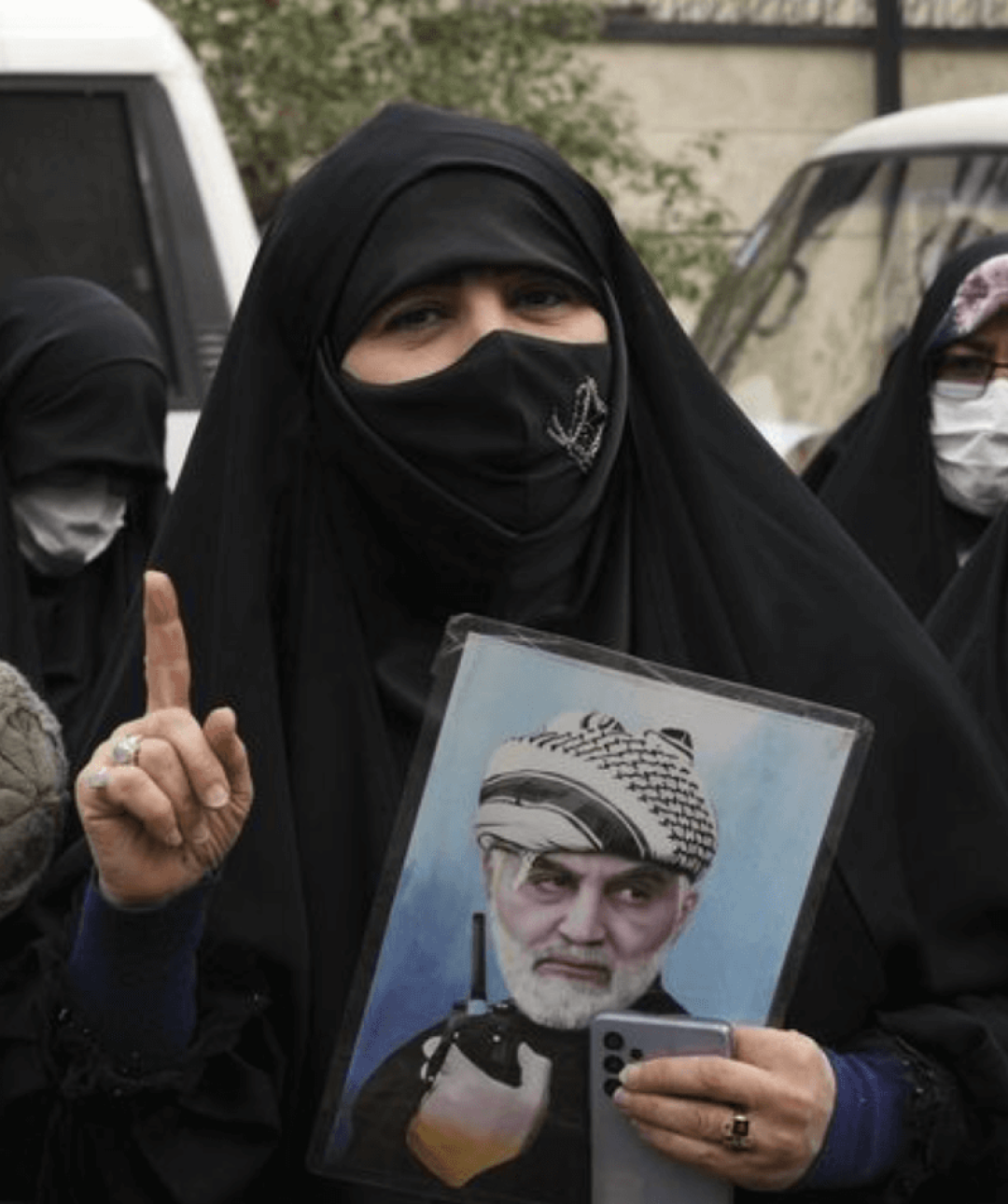 Iranian women holding photographs of Iranian leaders