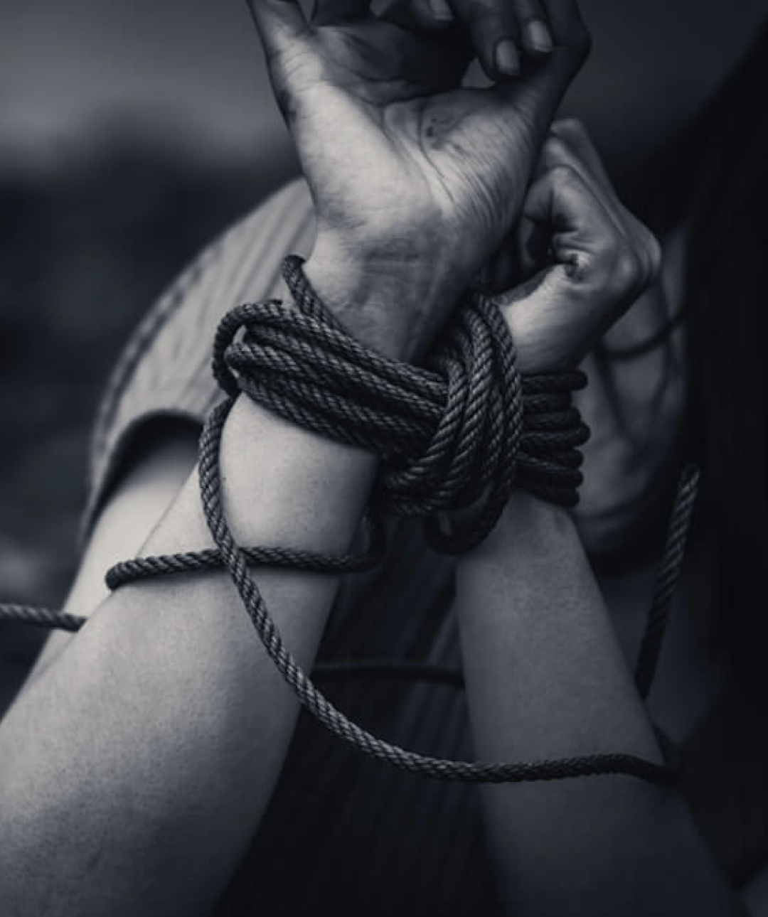 Hands tied together by a rope with a ominent black and white shade