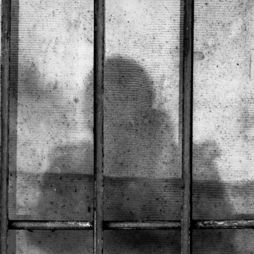 Shadow of a prisoner behind bars