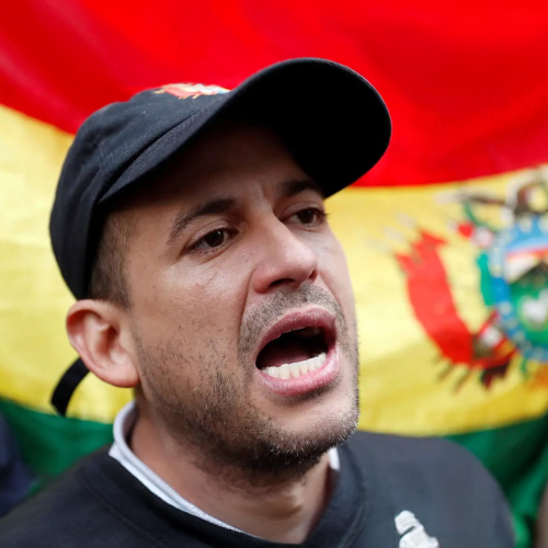 Bolivian activist with the Bolivian flag in the background