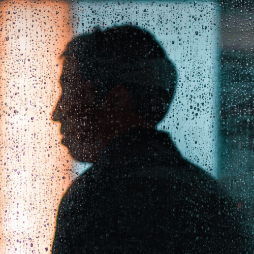 Figure of a man behind rained through glass