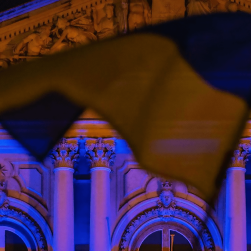 Ukrainian flag flying in front of a parliamentary building