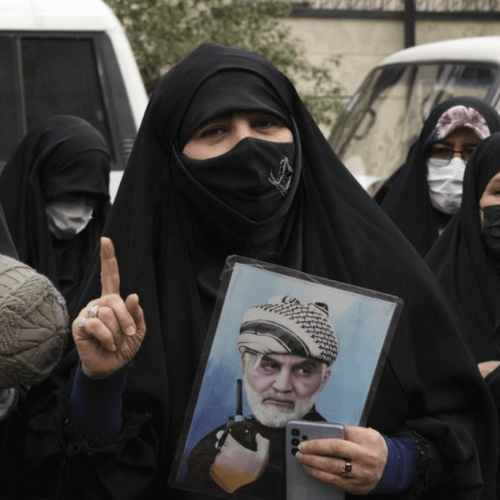 Iranian women holding photographs of Iranian leaders