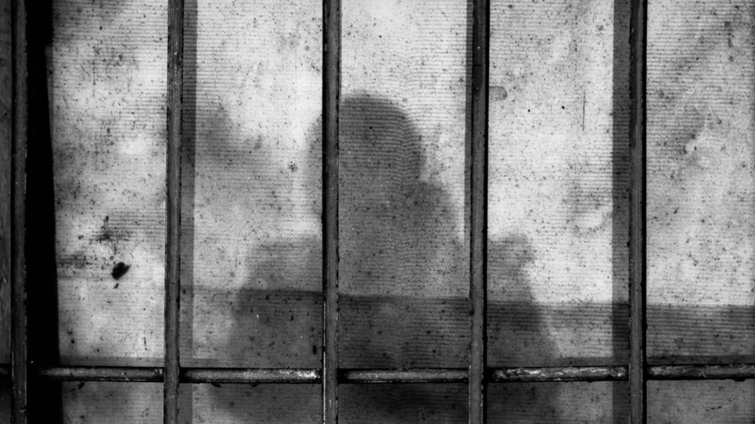 Shadow of a prisoner behind bars