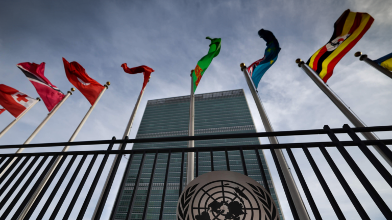 Photo of United Nations headquarters in New York displaying waving flags