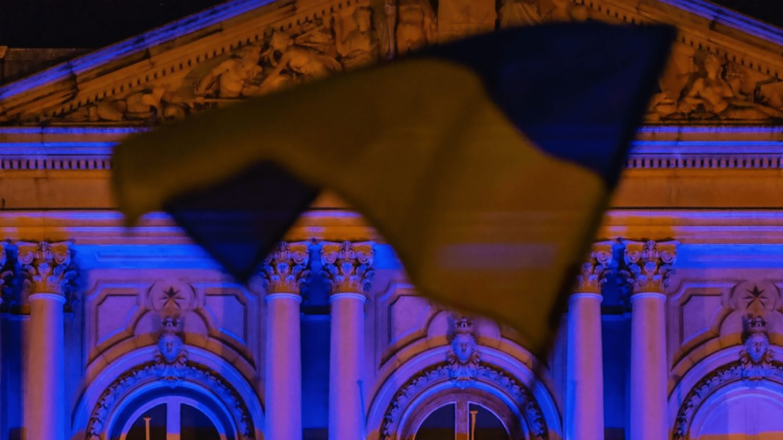 Ukrainian flag flying in front of a parliamentary building