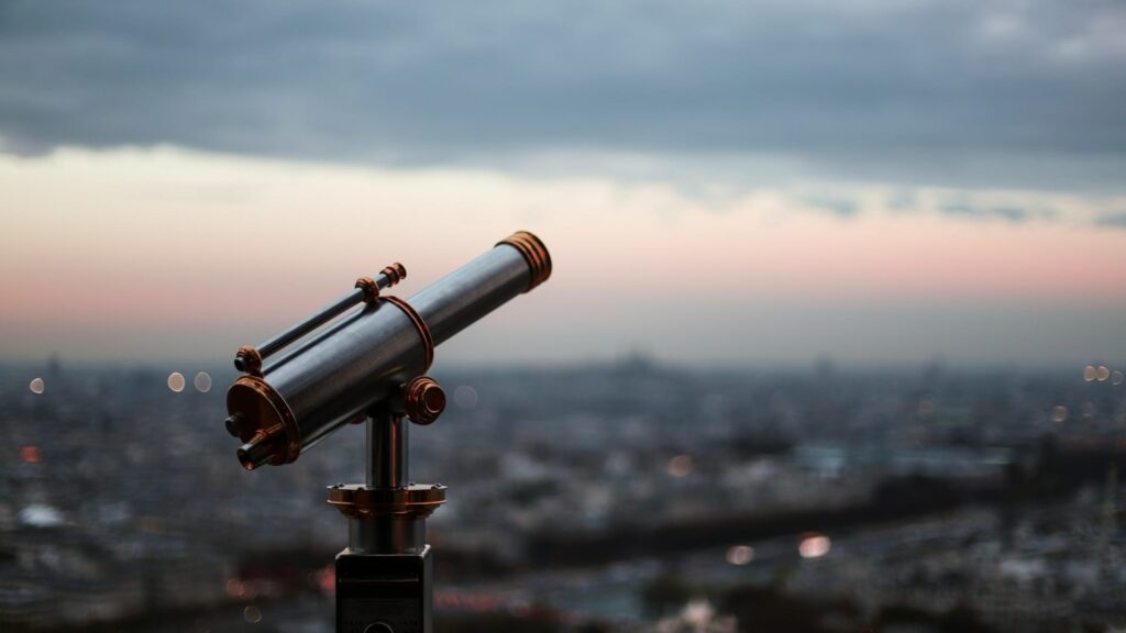 Telescope with the backdrop of a city in the distance
