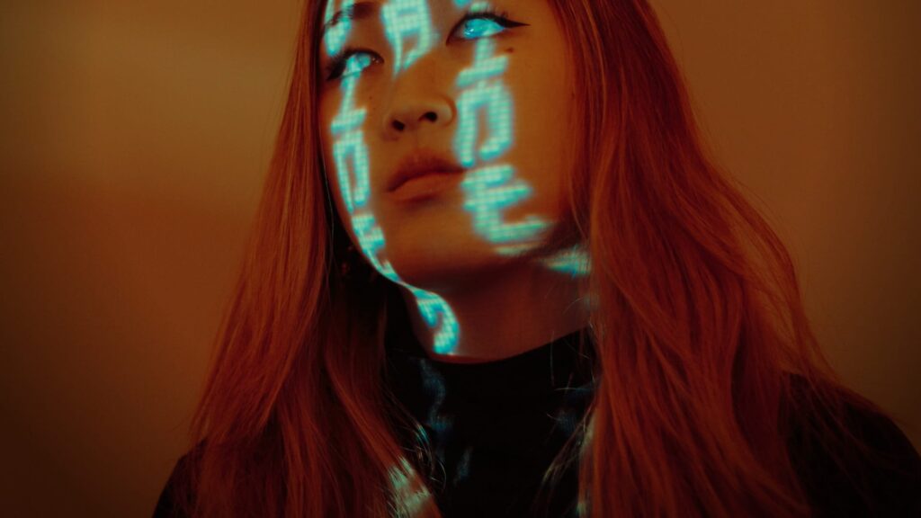 Numbers are projected on a person face with futuristic elements