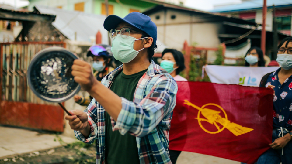 Youthquake Report - A Burmese protester bangs a pot during a demonstration in Mandalay against the military coup