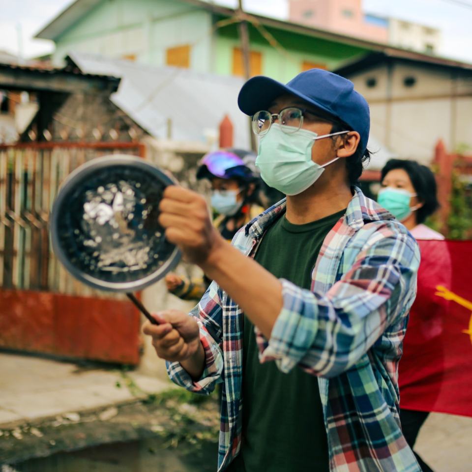 Youthquake Report - A Burmese protester bangs a pot during a demonstration in Mandalay against the military coup