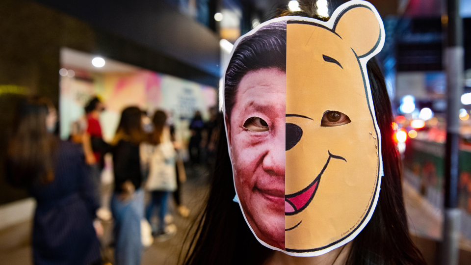 Youthquake Report - A protester wears a mask with a split image of Xi Jinping and Winnie the Pooh, a satiricization of the Chinese ruler