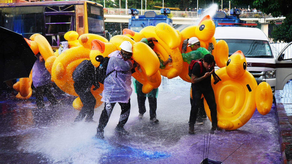 Youthquake Report - Protesters in Bangkok hold up rubber ducks to protect themselves from riot police firing water cannons, a tactic learned from Hong Kong protesters