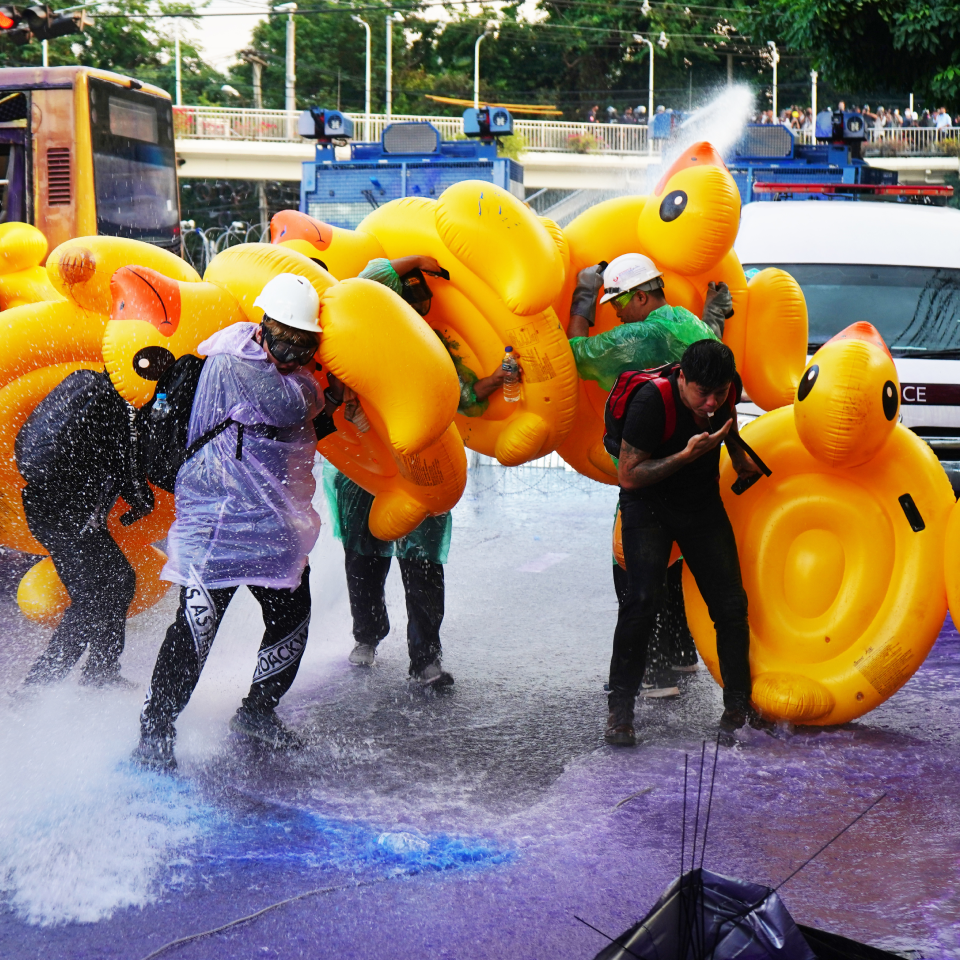 Youthquake Report - Protesters in Bangkok hold up rubber ducks to protect themselves from riot police firing water cannons, a tactic learned from Hong Kong protesters