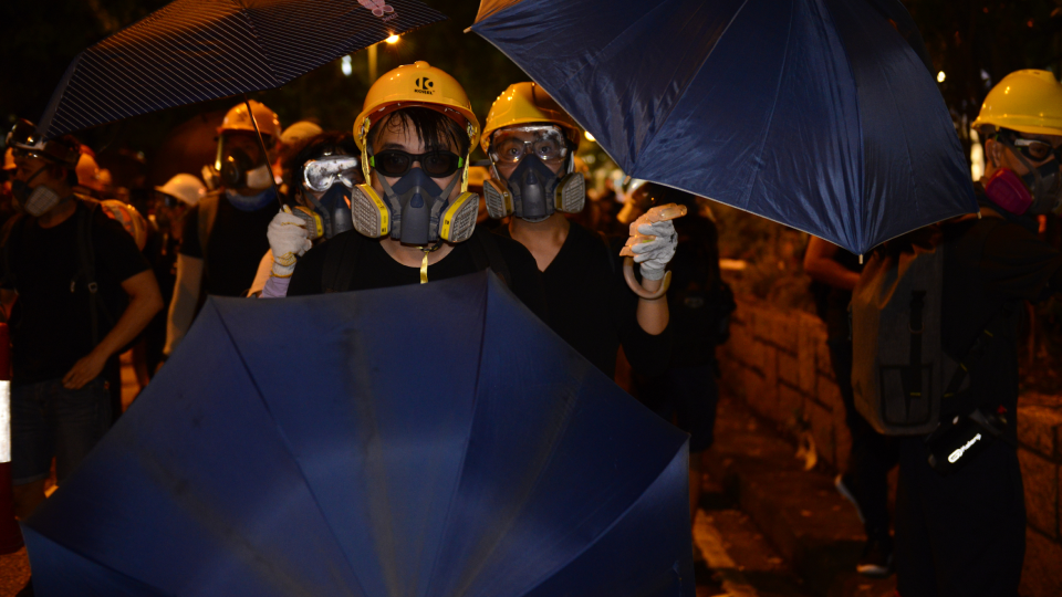 Youthquake Report - Protesters wear gas masks, yellow helmets, sunglasses, and other protective gear on their way to a demonstration