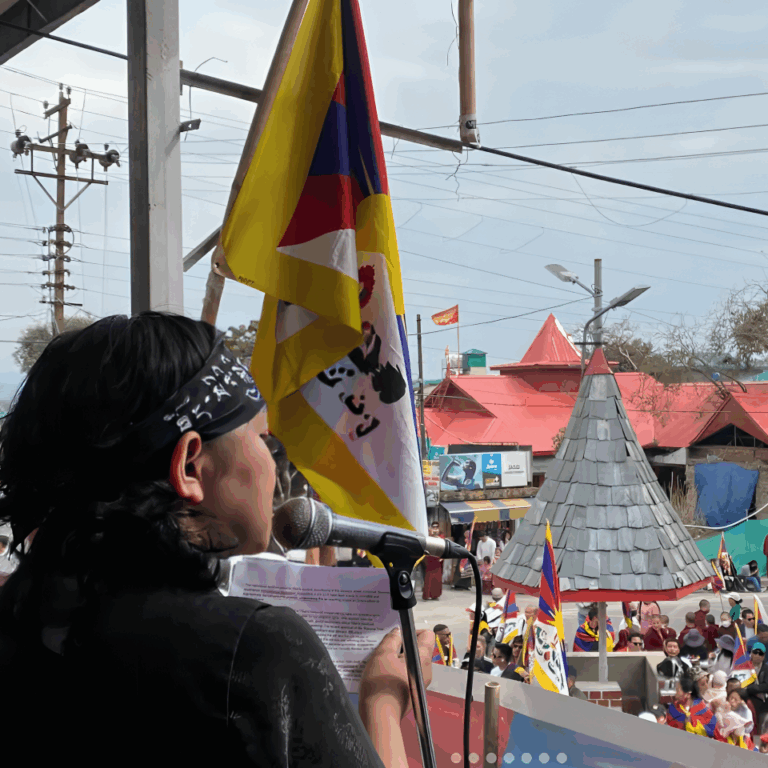 Youthquake Report - Students for a Free Tibet India Director Tenzin Passang speaks before a crowd waving the Tibetan flag on the 65th anniversary of the Tibetan National Uprising 1959 in Dharamsala, India